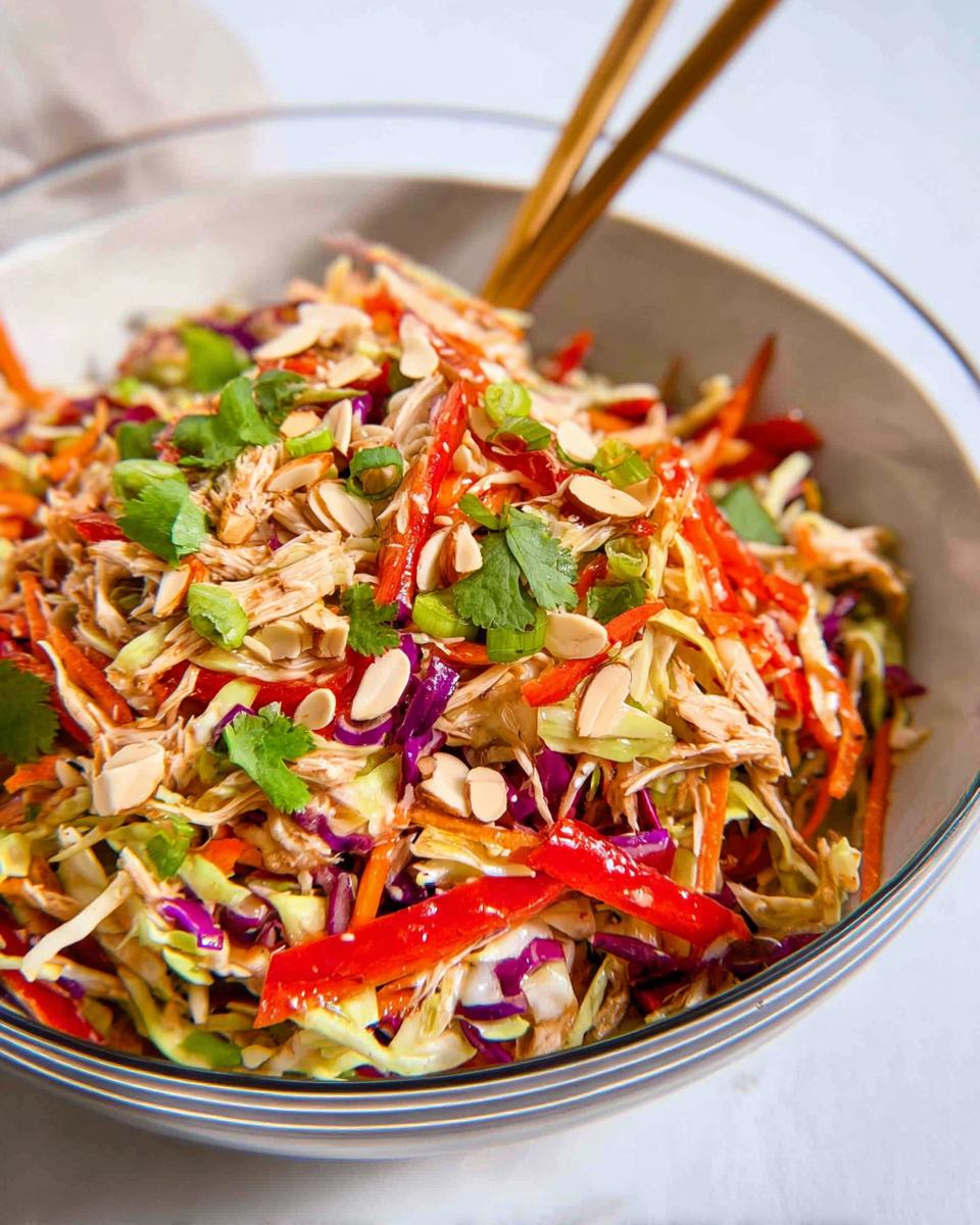 Your 30-Minute Chinese Chicken Salad with Sesame Dressing 4 A vibrant bowl of Chinese Chicken Salad with Sesame Dressing, featuring shredded chicken, colorful vegetables, and crunchy almonds.