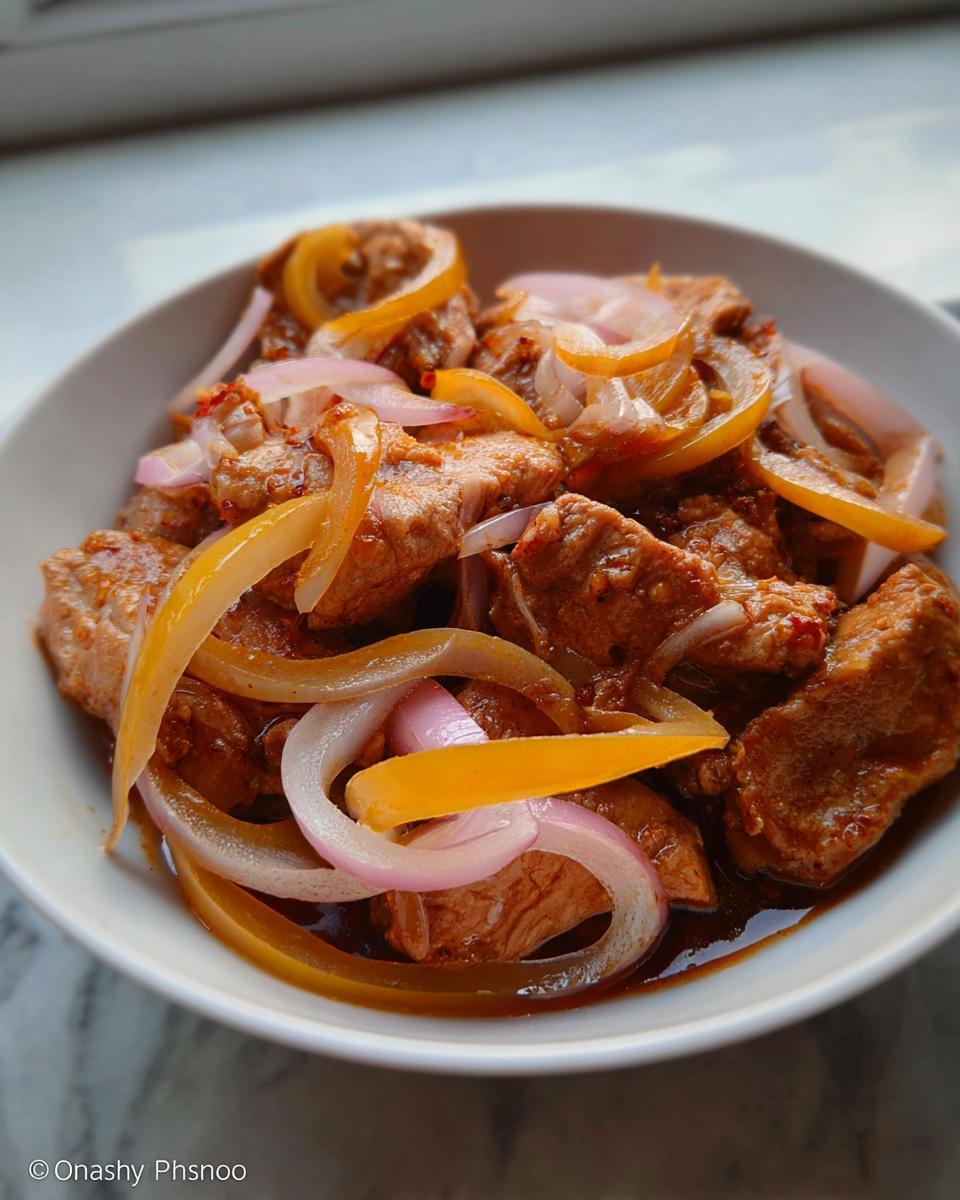 Amazing Easy Chicken Bistek: 30 Min Flavor 4 A close-up of Easy Chicken Bistek with Onions, featuring tender chicken pieces coated in a savory sauce with sliced onions.